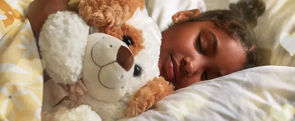 Girl sleeping with a teddy bear