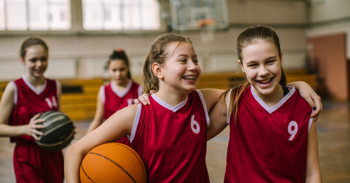 2 young teens on a basketball court