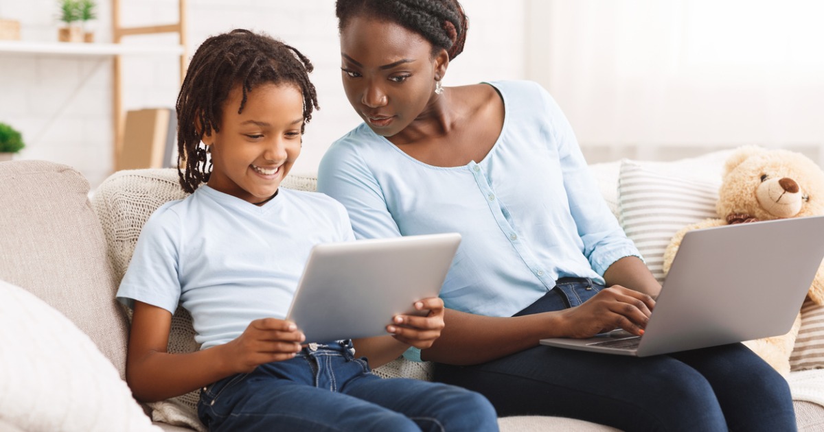 A mother and child look at an ipad