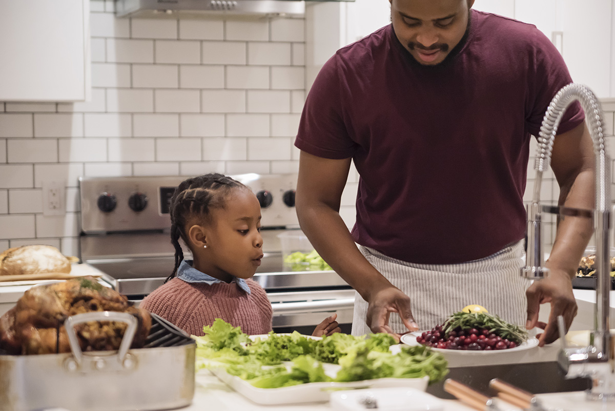 A father and his daughter cook food for Thanksgiving