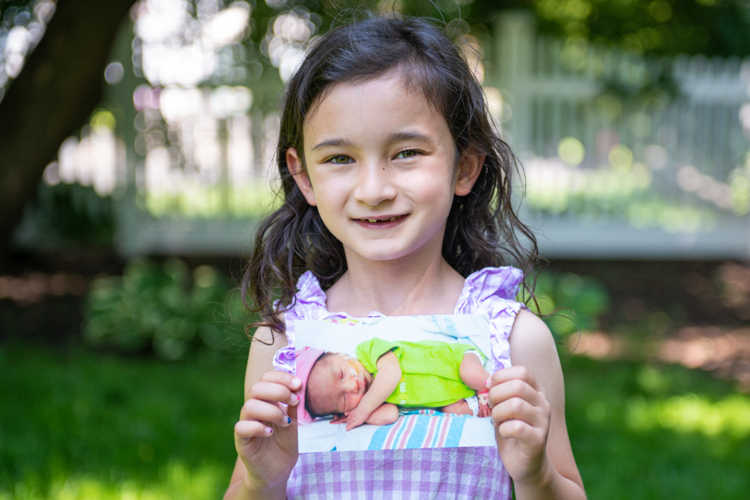 Claire holding a baby photo of herself