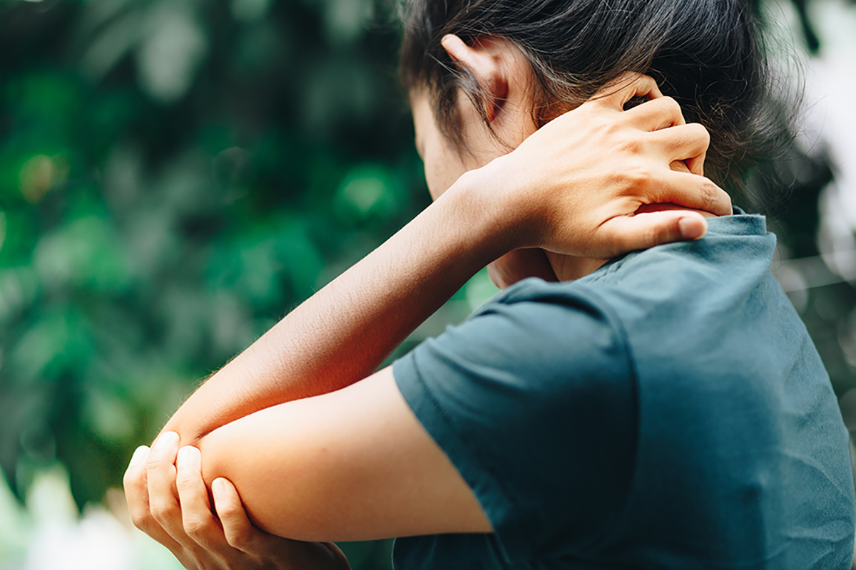 woman holding her elbow in pain