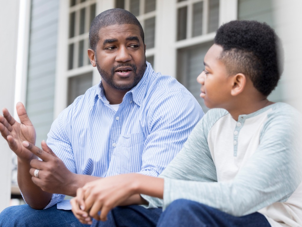 Attentive school-aged boy, listening to father during conversation