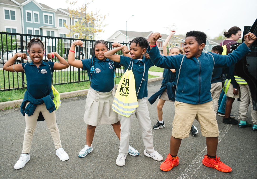 4 kids raising their arms showing their strength