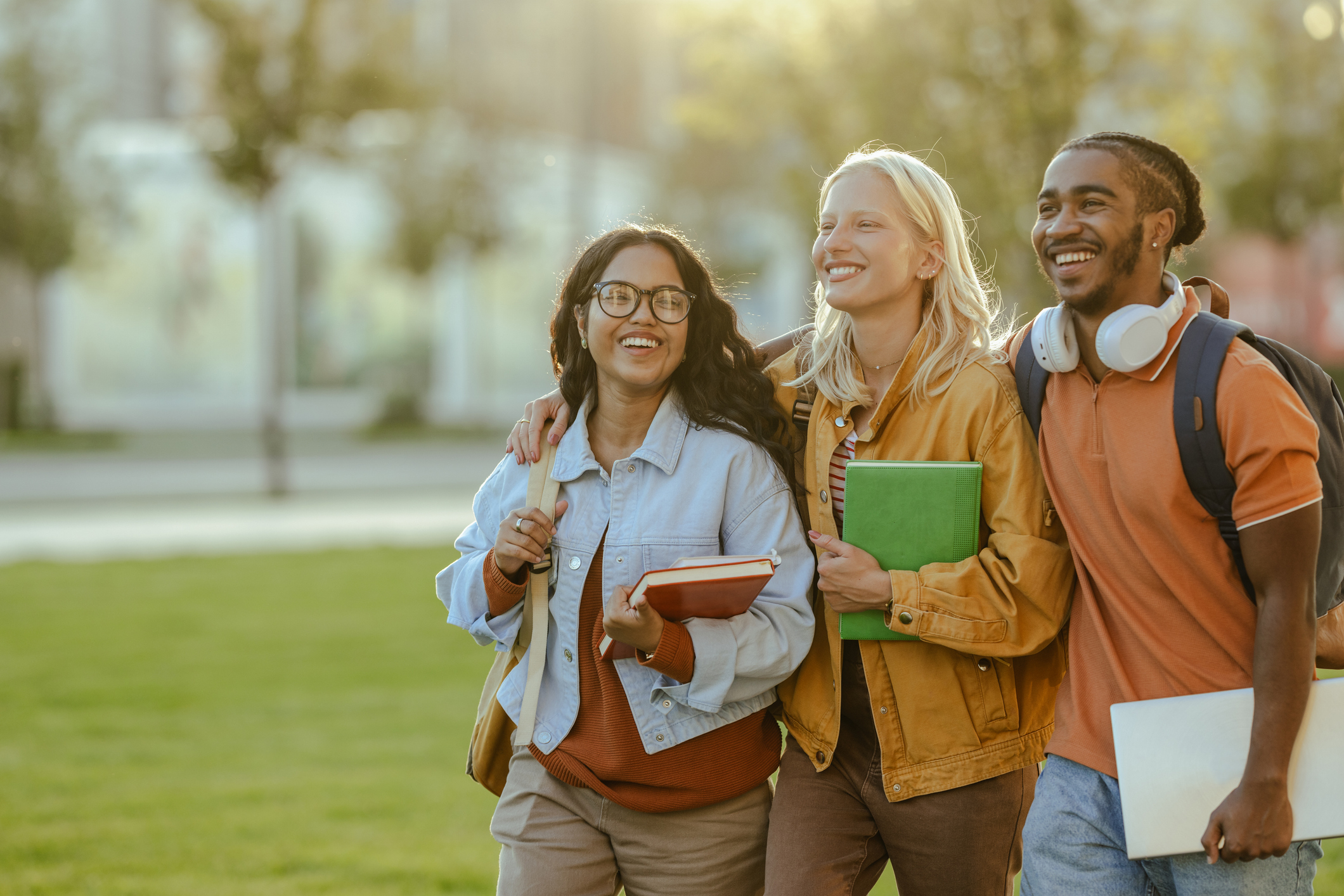 Three students walking on a college campus.