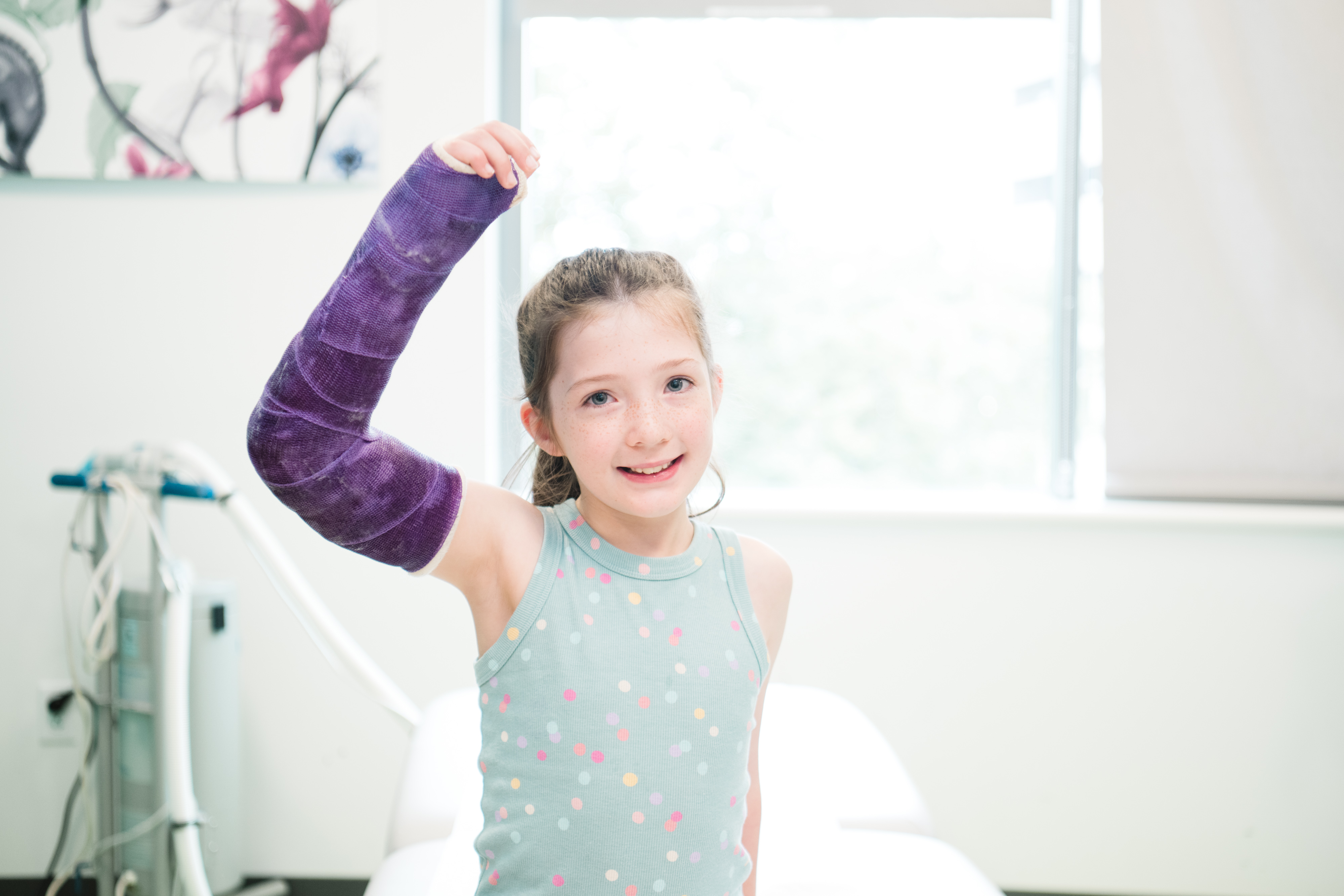 A patient with a cast in orthopedics clinic looks into the camera.