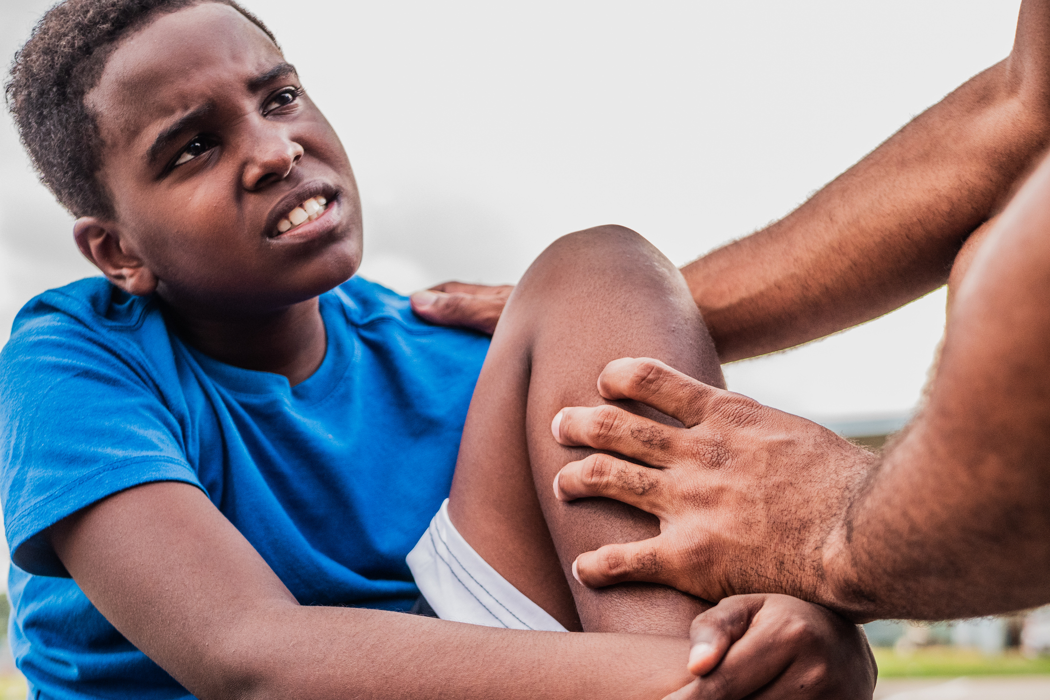 Child athlete with injured knee on field