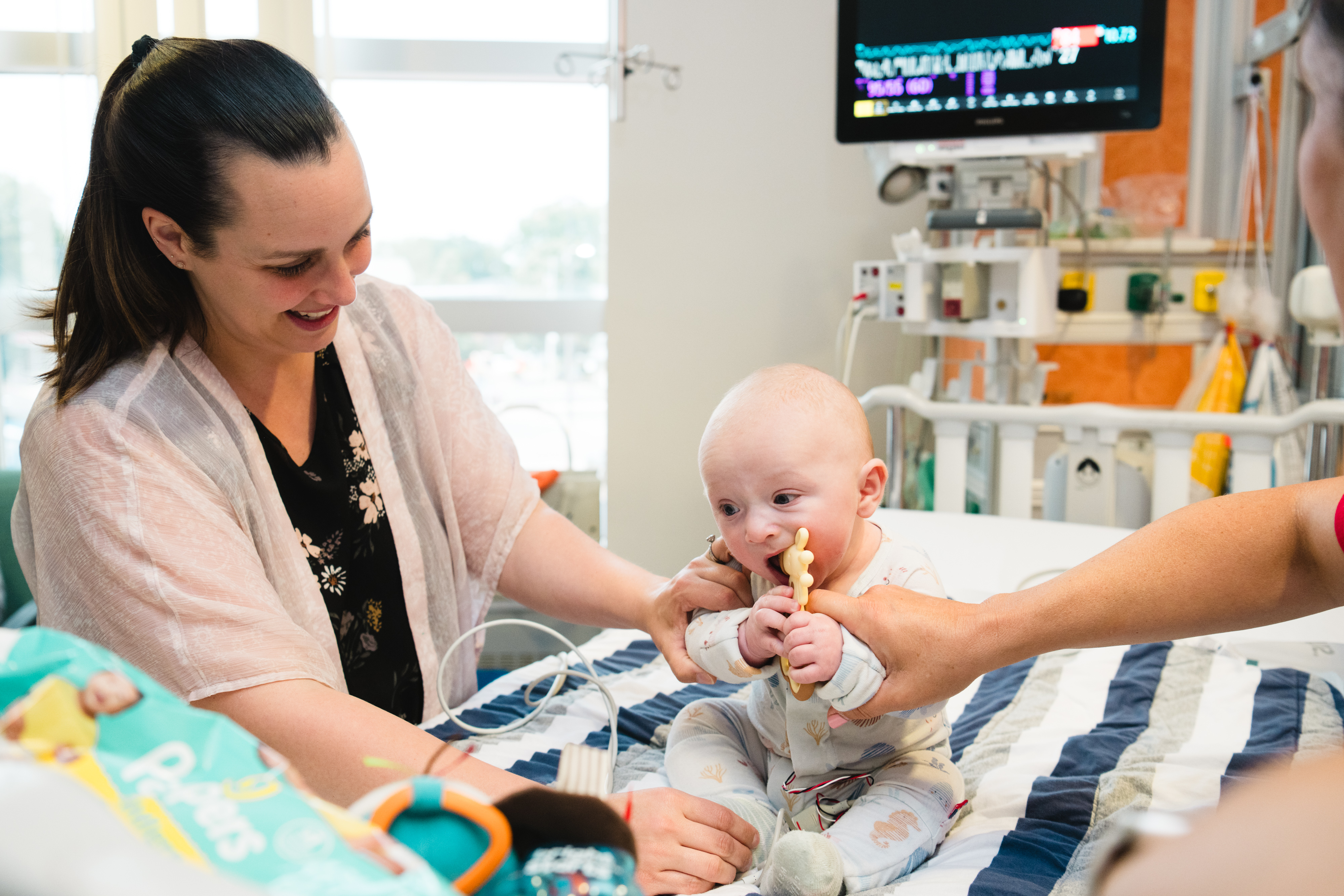 A baby inpatient with his mom in the cardiac ICU.