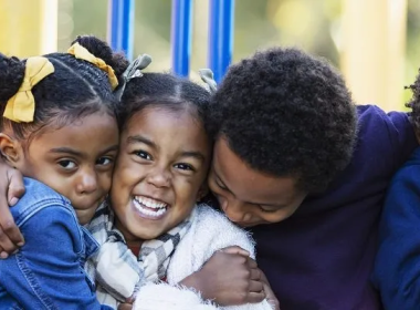 family hugging on a playscape