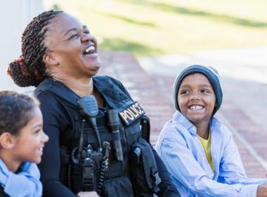 A police officer laughs with two children