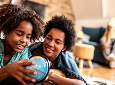 A mother and daughter look at a globe