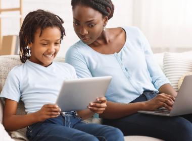 A mother and child look at an ipad