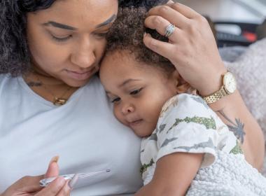 Mother snuggles her sick child