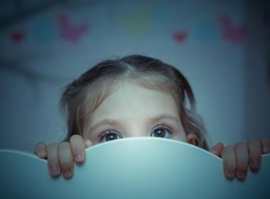 Young girl frightened in bed at night