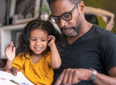 A father and his daughter reading a book