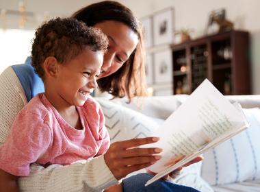 A mother reads a book with her son