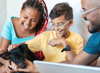 A family plays with their dog