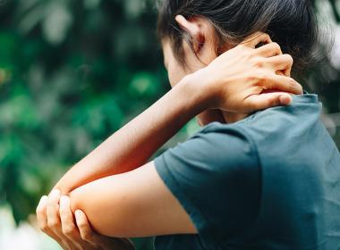 woman holding her elbow in pain
