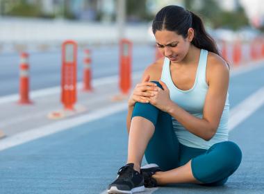 woman holding her knee in pain