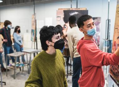 Two high schoolers work on a painting