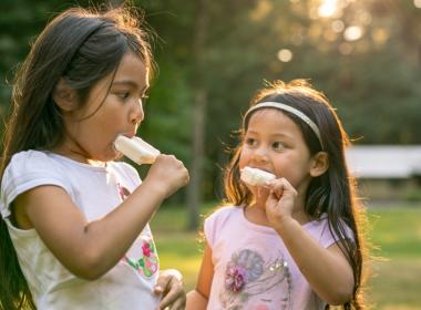 Sisters eating popsicles