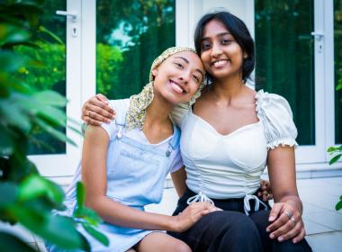 Two young adult female friends hugging