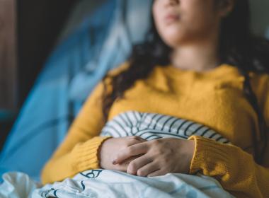 Teen laying in hospital bed