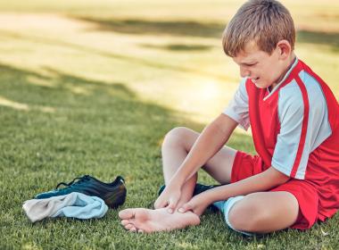 young soccer player with heel pain on field