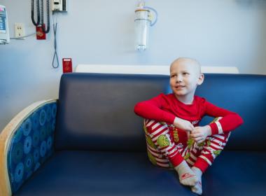 Child in hospital room, wearing holiday pajamas