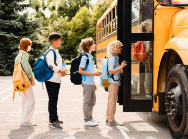 Kids getting on a school bus