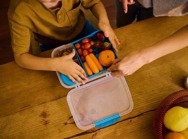 Child with healthy foods in lunch box