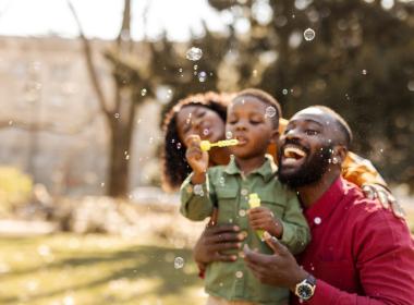 Family pblowing bubbles outside