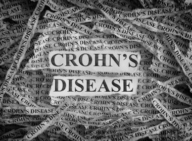 Torn pieces of paper with the words "Crohn's Disease"