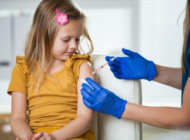 Young girl getting immunization in clinical setting