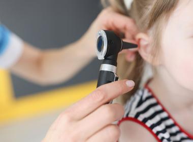 Close-up of child getting ear examined with otoscope 