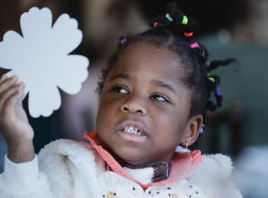 Adorable girl toddler holding a shamrock cutout. Was once extremely premature, now thriving