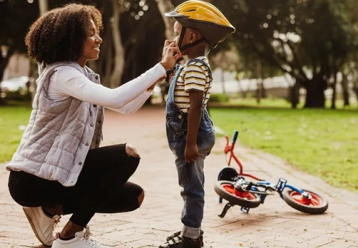 Mom fastening a bike helmet on a child