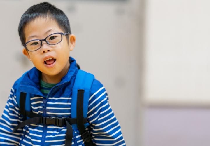 A young boy wearing a backpack