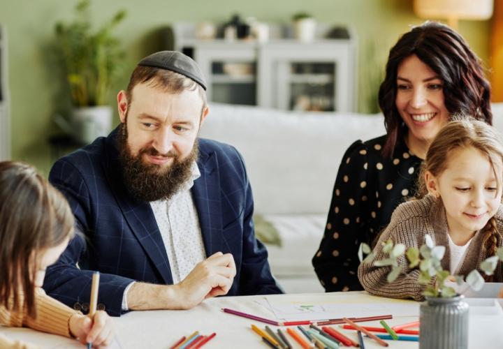 A Jewish family is having fun coloring with their kids