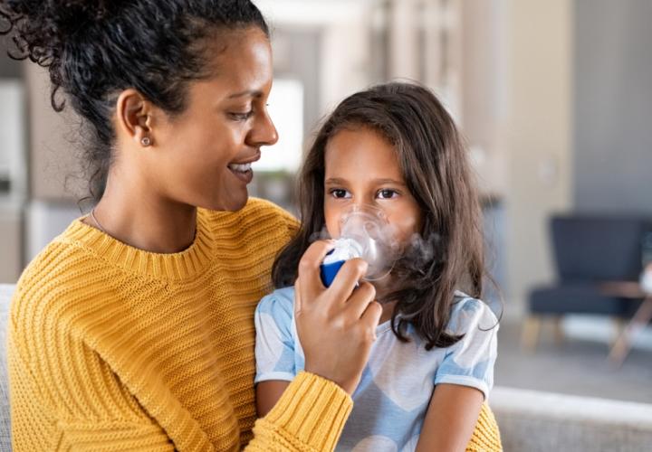Mother helping her daughter use a nebulizer