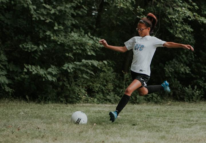 A young girl plays soccer