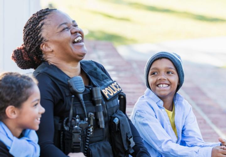 A police officer laughs with two children
