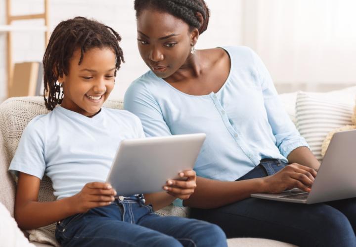 A mother and child look at an ipad