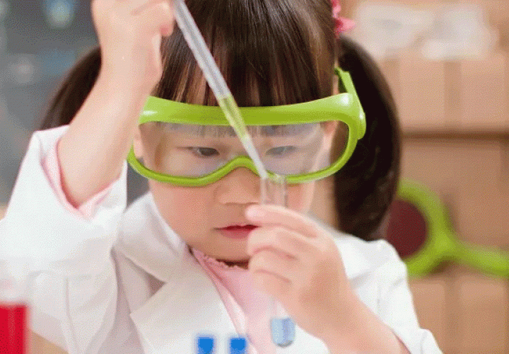 Girl wearing lab coat and goggles