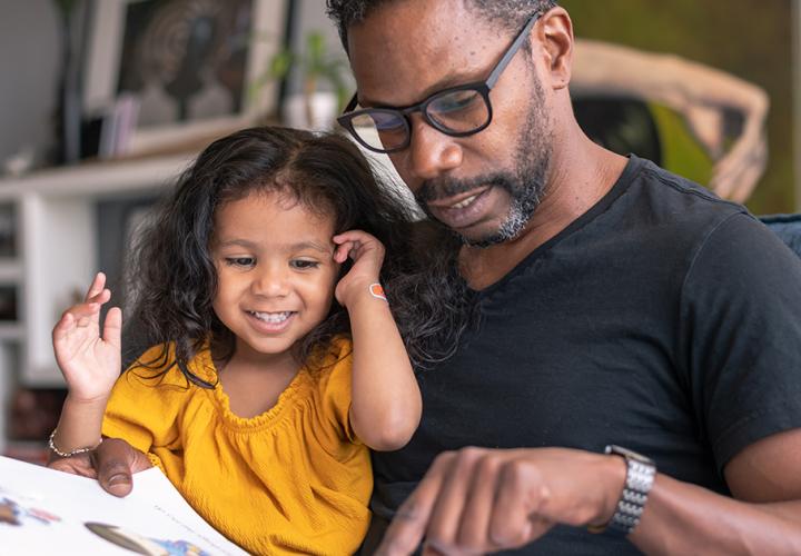 A father and his daughter reading a book