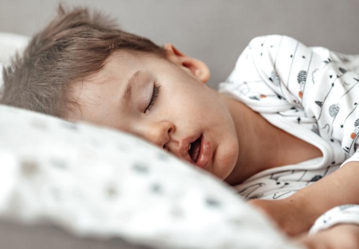 Young boy sleeping in bed