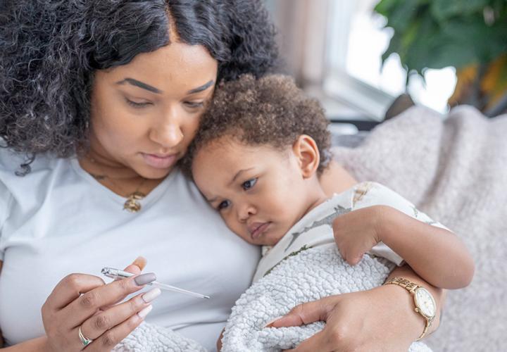 A mother checks her toddlers temperature