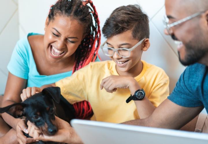 A family plays with their dog