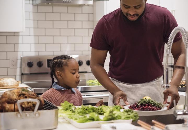 A father and his daughter cook food for Thanksgiving