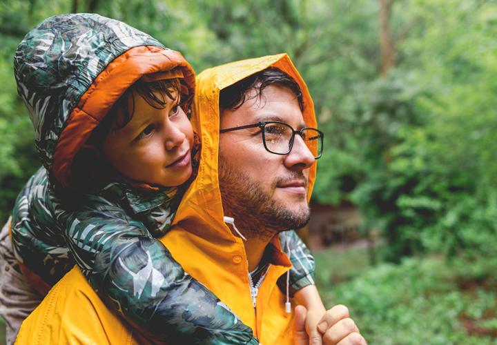 A father and son outside in the rain